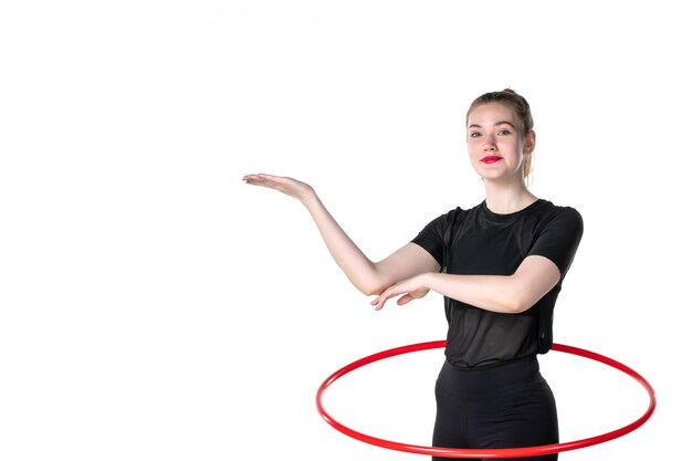 vista frontale giovane donna che lavora con hula hoop rosso su sfondo bianco colore stile di vita atleta donna salute corpo sport