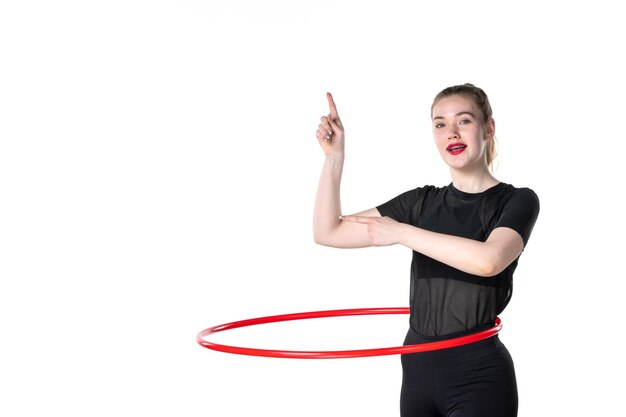 vista frontale giovane donna che lavora con hula hoop rosso su sfondo bianco colore stile di vita atleta donna salute yoga sport