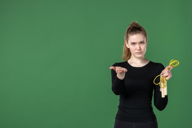 Vista frontale giovane donna che tiene la corda per saltare su green