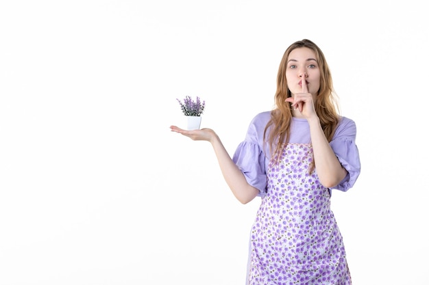 vista frontale giovane femmina che tiene piccola pianta su sfondo bianco pianta a foglia donna lavoro verde giardino fiorito erba natura pianta d'appartamento