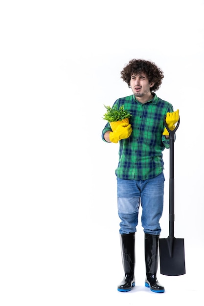 vista frontale giovane giardiniere maschio con pala e piccola pianta in vaso su sfondo bianco albero di lavoro campo di fiori acqua giardino erba uniforme