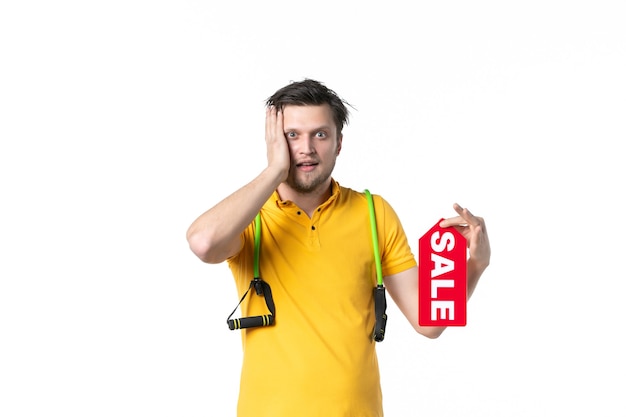 Vista frontale giovane maschio azienda vendita targhetta scritta su sfondo bianco lavoro sport umano commesso shopping palestra uniform