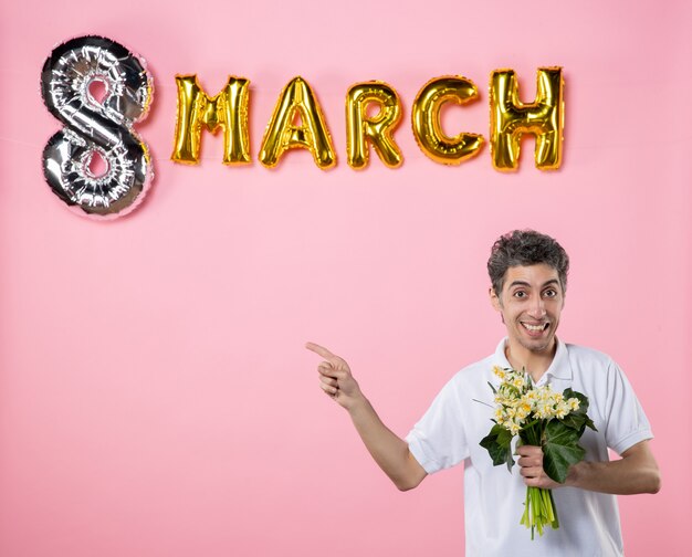 vista frontale giovane maschio che tiene fiori per donna con marzo decorato sfondo rosa sensuale femminile giorno delle donne emozione festa festa uguaglianza