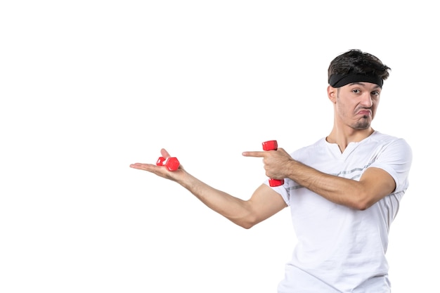 vista frontale giovane maschio che tiene i manubri rossi su sfondo bianco dieta salute atleta yoga sport in forma colore umano lifestyle