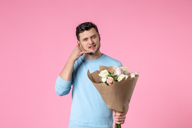 vista frontale giovane maschio con bouquet di bellissimi fiori su sfondo rosa data fun park sensuale womens day marzo matrimonio uguaglianza amore femminile