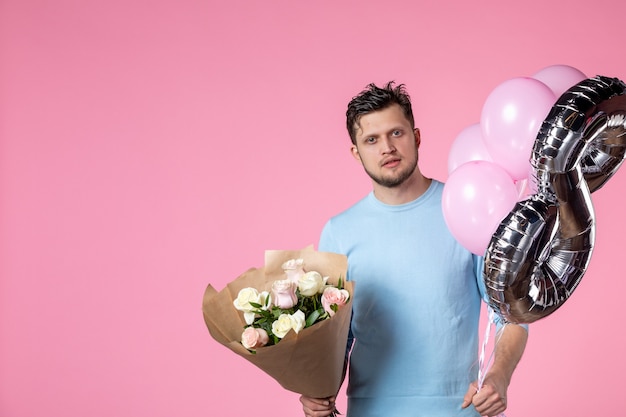 vista frontale giovane maschio con fiori e palloncini come marzo presente su sfondo rosa uguaglianza femminile giorno delle donne sensuale amore orizzontale matrimonio