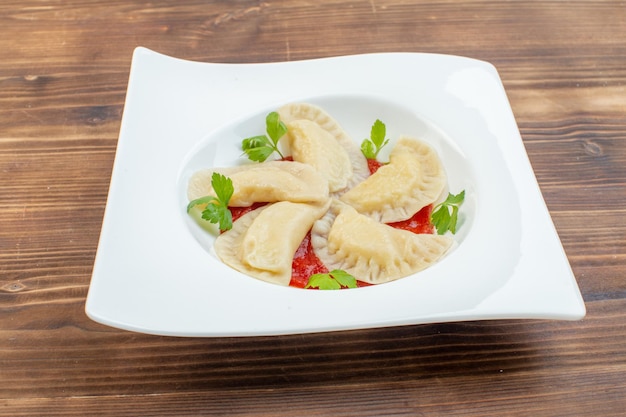 Vista frontale gustose torte al forno con concentrato di pomodoro all'interno della piastra su sfondo marrone servizio di cottura cuocere la cucina pasta ristorante pasta