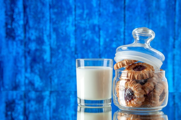 vista frontale gustosi biscotti dolci all'interno può con un bicchiere di latte su sfondo chiaro colore biscotto zucchero cibo torta colazione pasto mattutino