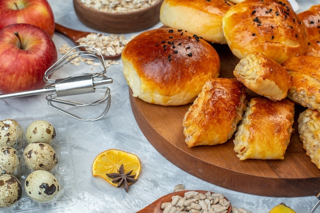 Vista frontale gustosi panini dolci con pasticcini cereali e uova su sfondo bianco torta di pasta torta di frutta cuocere il colore del latte cuocere