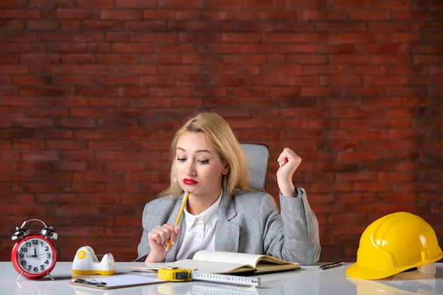 Vista frontale ha sottolineato ingegnere femminile seduto dietro il suo posto di lavoro