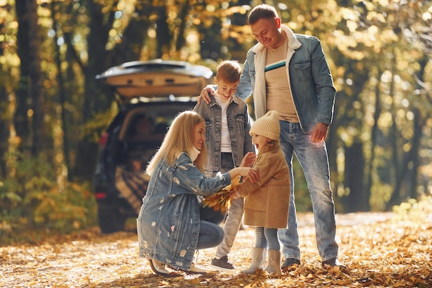 Vista frontale La famiglia felice è insieme nel parco in autunno