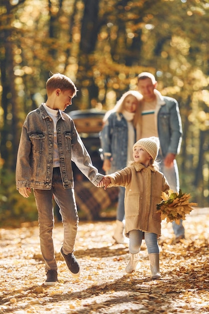 Vista frontale La famiglia felice è insieme nel parco in autunno