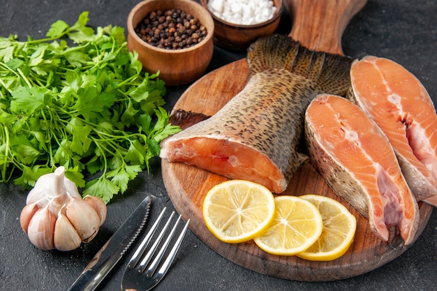 vista frontale pesce fresco con fettine di limone su sfondo scuro insalata oceano pasto a base di pesce pasto acqua pesce di mare carne