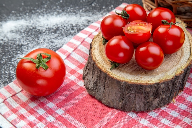 Vista frontale ravvicinata dei pomodori rossi e sull'asciugamano spogliato su uno sfondo di colore misto bianco nero