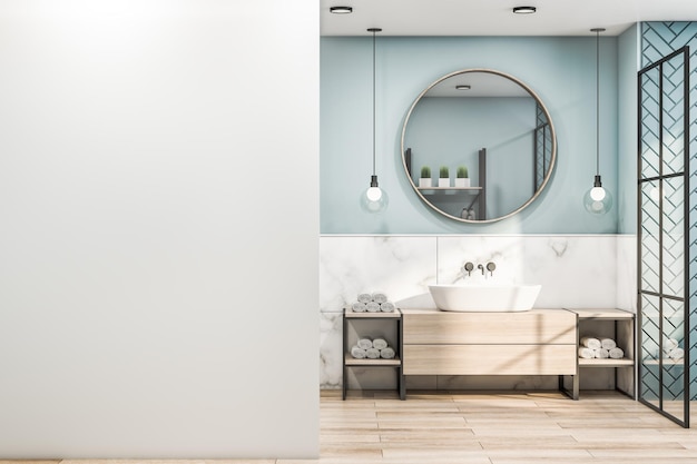 Vista frontale sul muro bianco vuoto in elegante bagno con ombra blu con specchio rotondo in legno lampadine moderne dall'armadio in legno superiore e racconti a spina di pesce nella zona doccia 3D rendering mockup