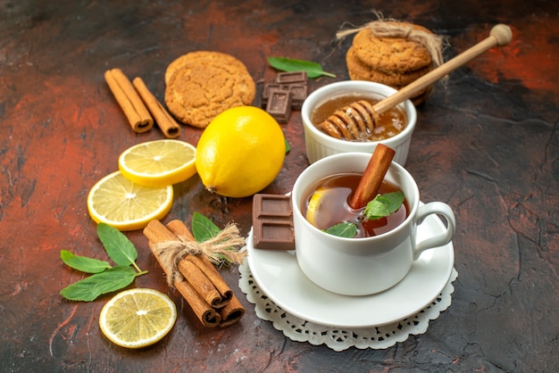 vista frontale tazza di tè con biscotti su sfondo scuro colore mattina dolce colazione frutta cerimonia tè biscotto