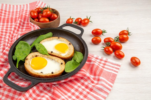 Vista frontale toast all'uovo all'interno della padella con pomodori rossi su sfondo bianco pranzo cibo tè pasto piatto pane colore colazione