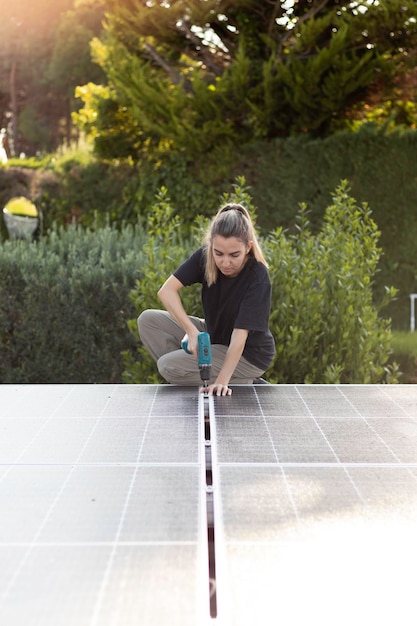 Vista frontale verticale del servizio di lavoro della giovane donna dell'ingegnere che controlla l'installazione della cella solare sul