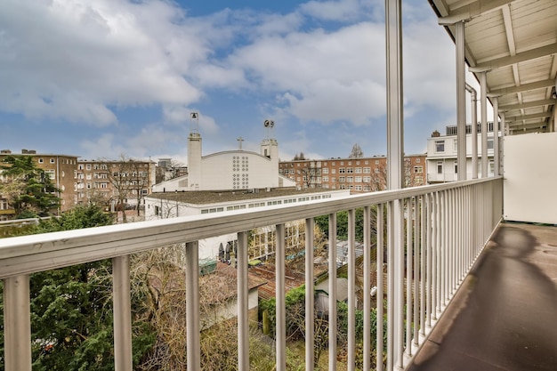 Vista generale del balcone con pavimento in cemento con recinzione metallica e vista sul paesaggio cittadino
