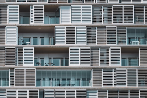 Vista geometrica frontale delle persiane e dei balconi di un edificio urbano disposti in file continue