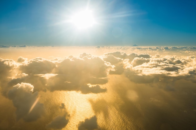 Vista in aereo del bellissimo paesaggio con nuvole color oro oceano con picco di montagna e sole splendente