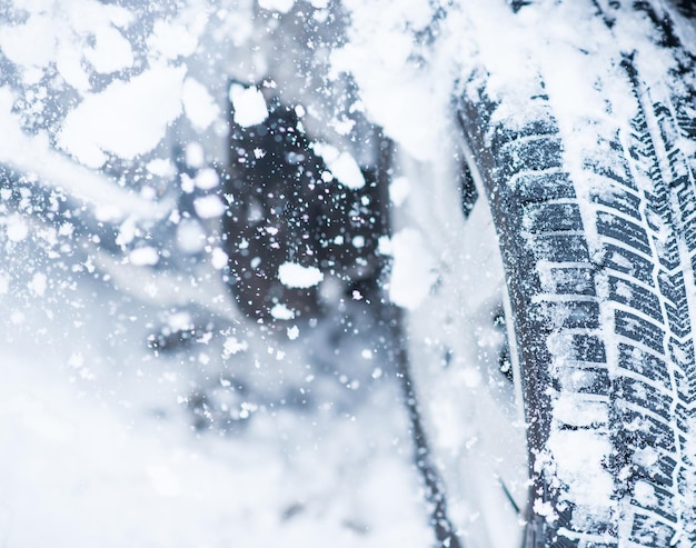 Vista ingrandita degli pneumatici invernali su una strada coperta di neve nei mesi invernali con gelo freddo.