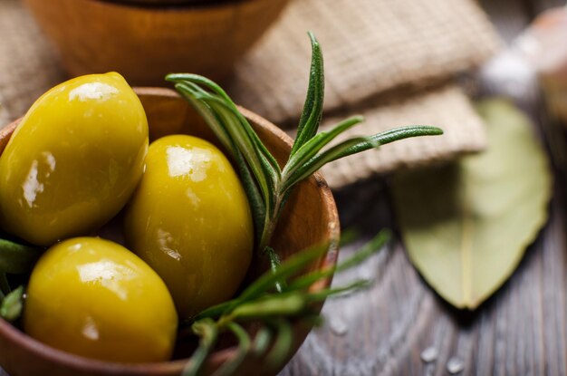 Vista ingrandita di oli di olive verdi e spezie sul tavolo da cucina. Concetto di cucina