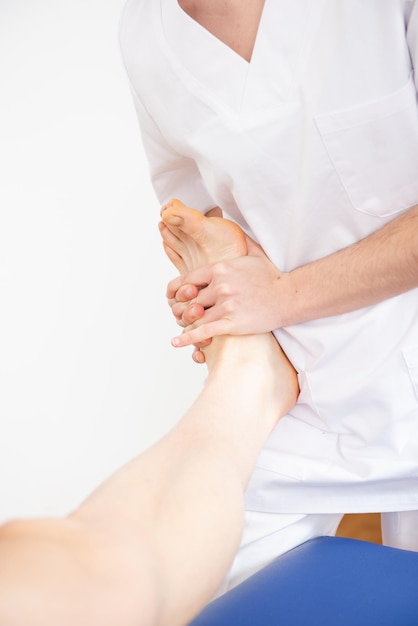 Vista ingrandita di un fisioterapista che tratta la mobilità del piede e della caviglia di un paziente.