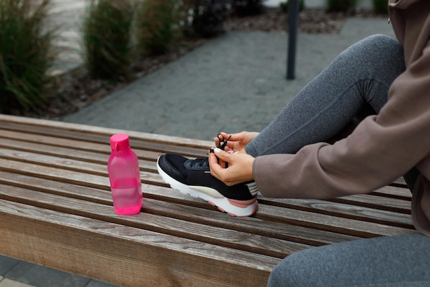 Vista ingrandita di una donna sportiva che lega i lacci delle scarpe