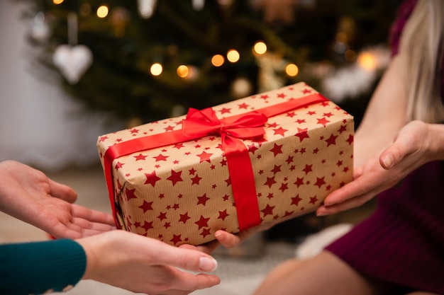 Vista ingrandita mentre si fa un regalo con un fiocco rosso durante il Natale