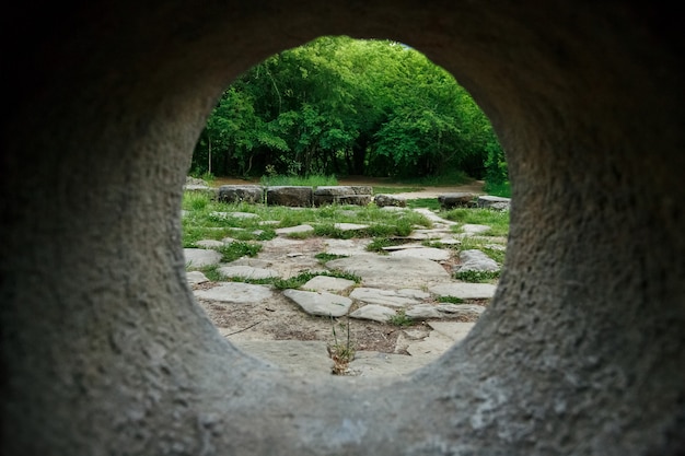 Vista interna di un dolmen di pietra attraverso un buco in una foresta di montagna nella valle del fiume Jean