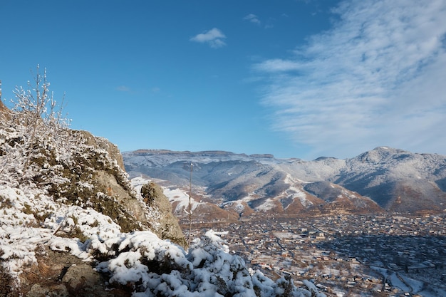 Vista invernale dalla montagna alla cittadina neve rocce e pietre villaggio in lontananza