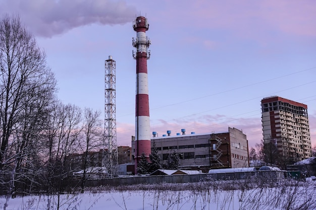 Vista invernale di una centrale termica con camino fumante