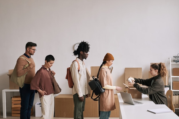 Vista laterale a diversi gruppi di persone in fila durante l'evento di aiuto e donazioni, spazio di copia