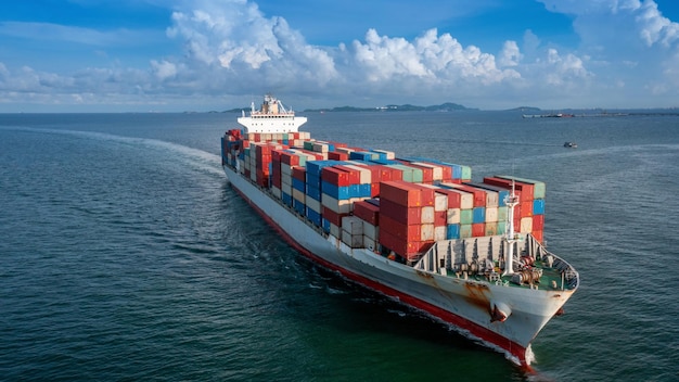 Vista laterale aerea della nave da carico che trasporta container e funziona per l'esportazione di merci dal porto di scalo merci ad altre navi da trasporto merci oceaniche