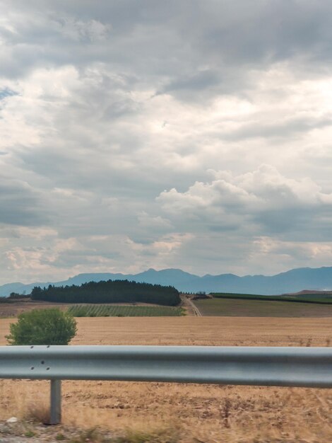 Vista laterale dalle montagne dei campi di auto tempo nuvoloso