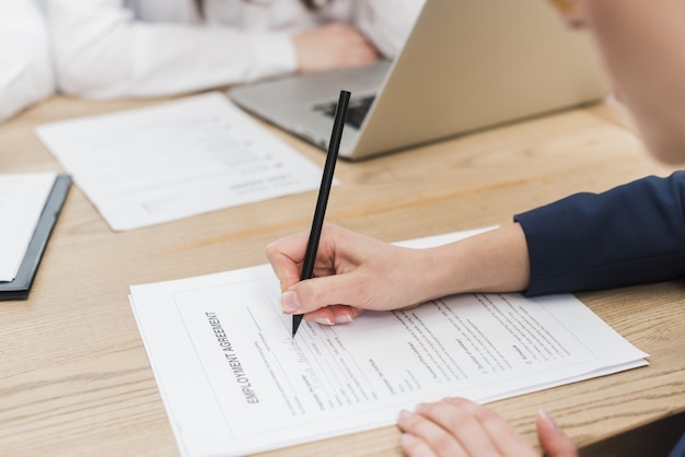 Vista laterale del contratto di lavoro di firma della donna