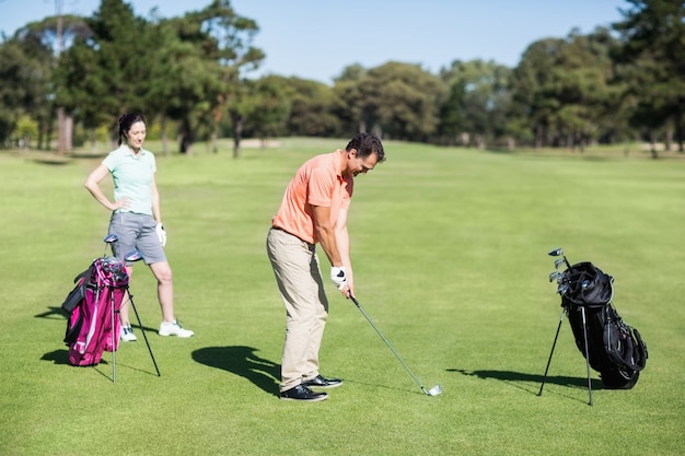 Vista laterale del giocatore di golf che prende colpo