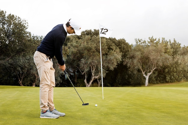 Vista laterale dell'uomo che gioca a golf