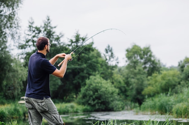 Vista laterale dell&#39;uomo che pesca nel lago