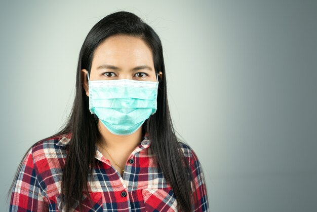 Vista laterale della donna in maschera a causa dell'inquinamento atmosferico e dell'epidemia in città. Protezione da virus, infezione, gas di scarico ed emissioni industriali