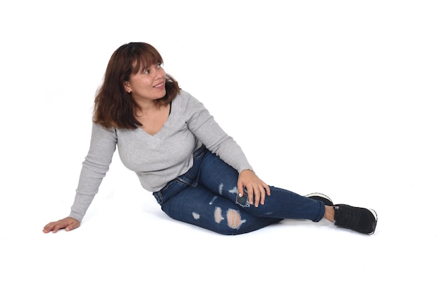 Vista laterale della donna seduta sul pavimento sfondo bianco