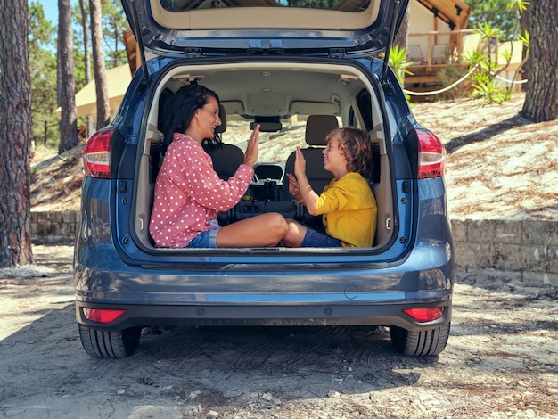 Vista laterale della madre ottimista con il figlio che si guardano mentre giocano a Pat a cake nel camion dell'automobile