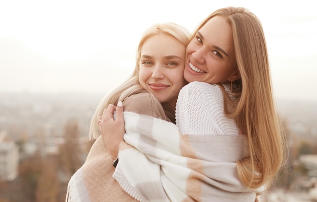 Vista laterale delle migliori amiche femminili felici che stringono a sé