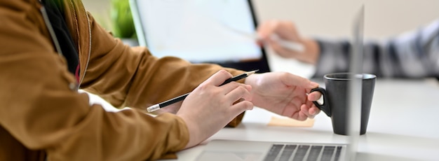 Vista laterale delle persone di affari che lavorano insieme al computer portatile e alla compressa digitale