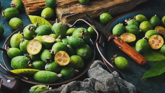 Vista laterale di feijoas verdi freschi naturali su sfondo di pietra nera