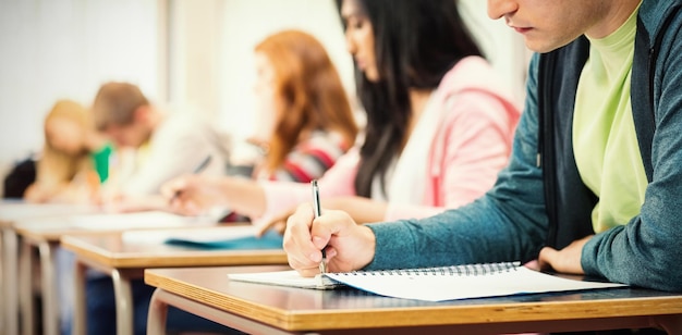 Vista laterale di giovani studenti che scrivono appunti in classe