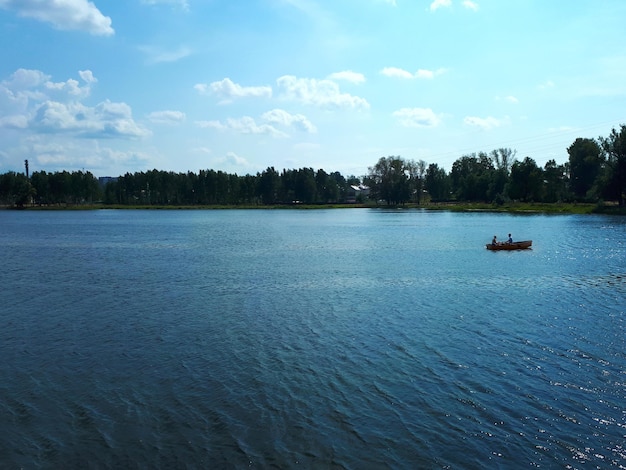 Vista laterale di persone che navigano in barca su un fiume in estate in una giornata calda e soleggiata