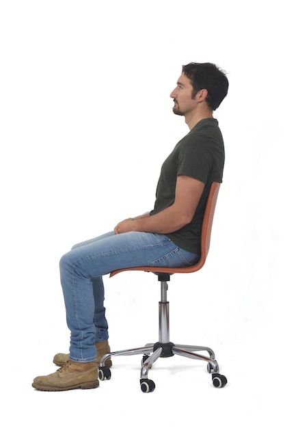 Vista laterale di un ritratto completo di uomo seduto su una sedia su sfondo bianco