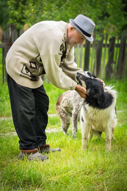 Vista laterale di un uomo anziano con i cani sul campo erboso